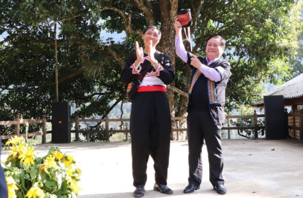 Bộ trưởng Lê Minh Hoan vui vẻ đón nhận món quà lưu niệm của người dân bản Sin Suối Hồ gửi tặng. Ông đánh giá cao cách làm du lịch thông minh, thân thiện của người dân bản địa. Ảnh: Laichau.gov.vn.