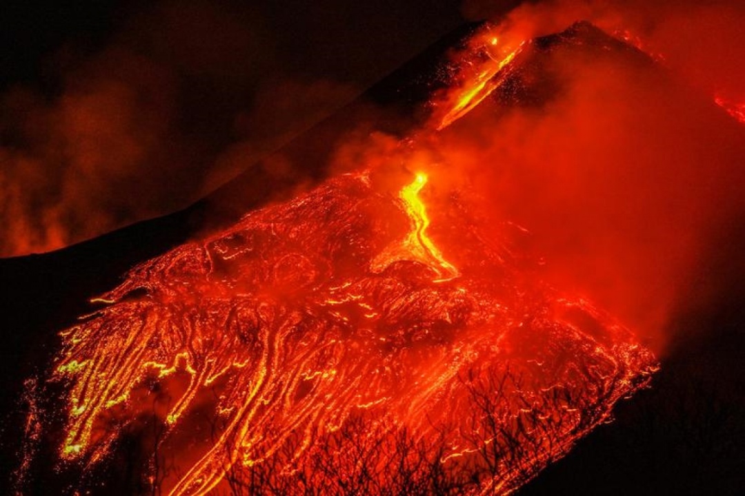 Dòng dung nham đỏ rực phun trào từ núi lửa Etna, núi lửa hỏa động mạnh nhất ở châu Âu, nhìn từ làng Formazzo, Italy, ngày 23/2/2021.