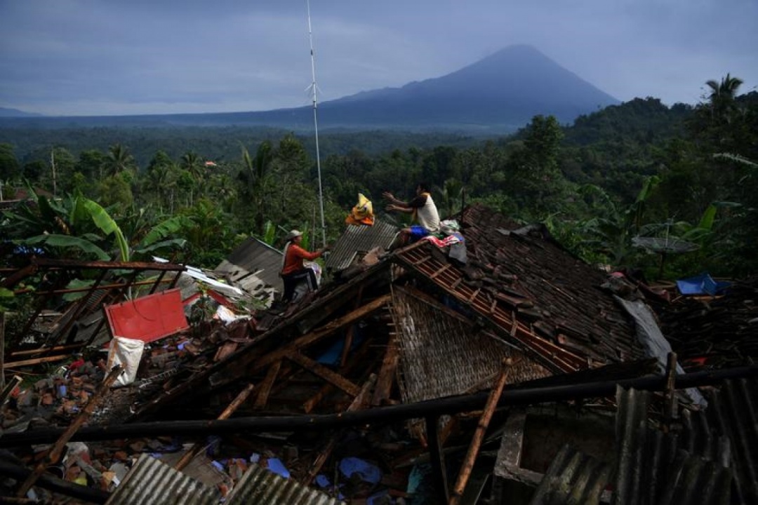 Người dân thu nhặt đồ đạc từ một ngôi nhà bị hư hại do động đất ở Lumajang, tỉnh Đông Java, Indonesia, ngày 11/4/2021. 