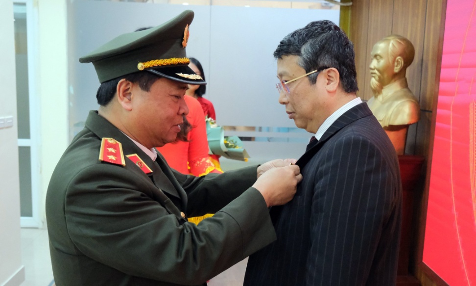 Trung tướng Nguyễn Đình Thuận gắn Kỷ niệm chương của Bộ trưởng Bộ Công an cho ông Hoàng Trung. Ảnh: Minh Phúc.