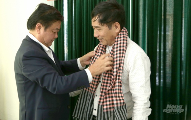 Bộ trưởng Lê Minh Hoan (trái) tặng chiếc khăn được sản xuất tại Đồng Tháp cho ông Trần Thanh Sơn, Giám đốc HTX Sản xuất Kinh doanh Dịch vụ nông nghiệp Bình Định. Ảnh: Minh Phúc.