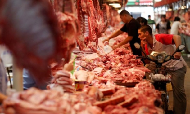 Một người dân Trung Quốc dừng chân chờ mua thịt lợn ở thủ đô Bắc Kinh. Ảnh: Reuters