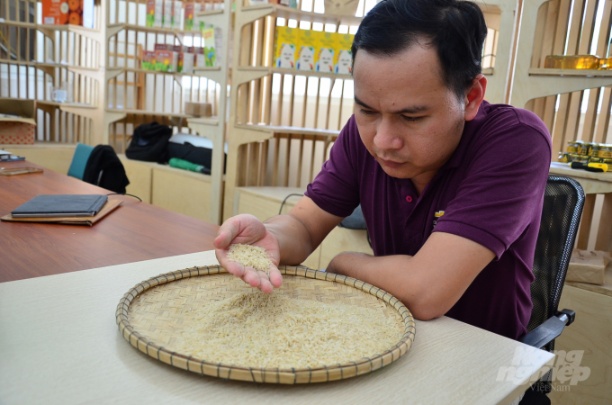 Cường đang kiểm tra chất lượng gạo. Ảnh: Dương Đình Tường.