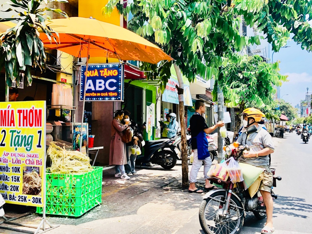 Trưa nắng, nhiều khách đi đường ghé mua nước mía  ở một tiệm trên đường Nguyễn Đình Chiểu (quận 3, TPHCM) - ẢNH: T.HOA