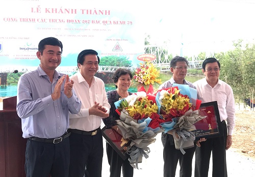 Nguyên Chủ tịch nước Trương Tấn Sang (phải) và lãnh đạo địa phương tặng hoa cho các nhà tài trợ.