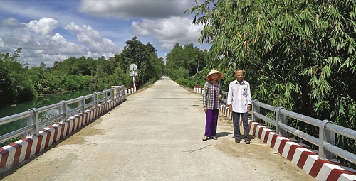 Vợ chồng ông Nguyễn Văn Lắm (xã Mỹ Thạnh Đông, huyện Đức Huệ) bên cây cầu Kênh Nội Đồng.