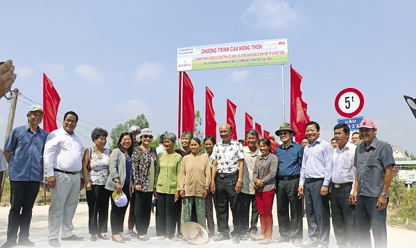 Nguyên Chủ tịch nước Trương Tấn Sang (thứ tư từ phải sang) và các đại biểu chụp hình lưu niệm cùng bà con địa phương trong ngày khánh thành cây cầu mới.