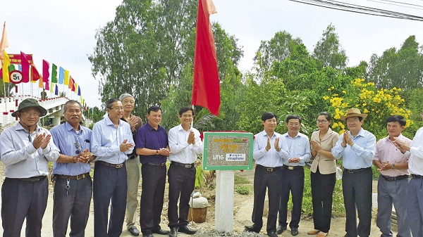Nguyên Chủ tịch nước Trương Tấn Sang (thứ 2 từ phải qua) cùng các đại biểu chụp hình lưu niệm bên cây cầu mới.