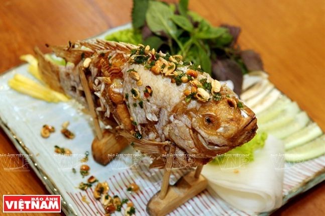 Cá chiên xù quấn với bánh tráng cùng các loại rau sống, chuối xanh, dứa, khế chua và ăn nóng. Nguồn: vietnam.vnanet.vn