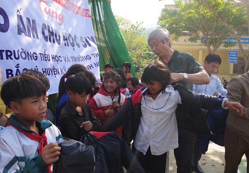 Ông Nguyễn Đức Quang - Tổng Biên tập Tạp chí Nông thôn Việt trao tặng áo ấm cho các em học sinh.
