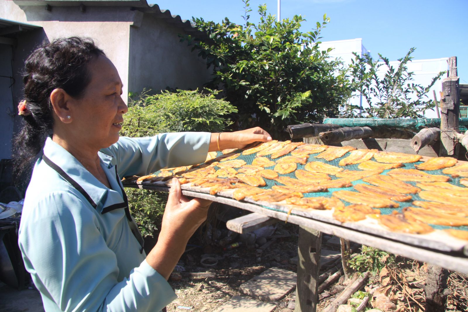 Những tháng gần tết, bà Nguyễn Thị Hóa ép chuối phơi khô để chuẩn bị nguyên liệu làm nhân bánh in Long Hựu. Ảnh: An Nhiên.