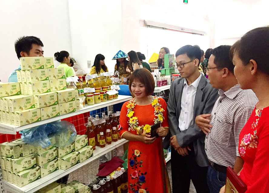 Chị Trần Thị Thuần (thứ tư từ phải sang) giới thiệu sản phẩm “Trà thảo dược” của Hợp tác xã Tâm Ngọc (huyện Sóc Sơn) với khách hàng tại hội chợ do Hội Liên hiệp phụ nữ thành phố Hà Nội tổ chức tháng 10-2020.
