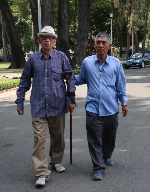  ông Ngô Quang Khải chống gậy cùng người thân ra về sau khi vào viếng thăm Thủ tướng Phan Văn Khải. 
