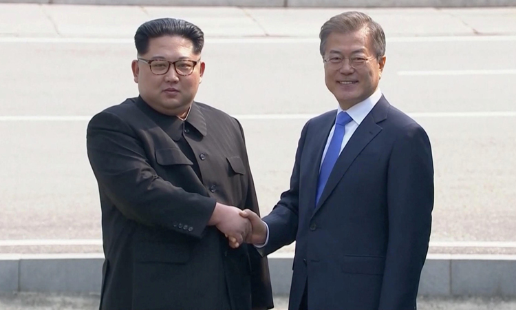 Chủ tịch Triều Tiên Kim Jong-un (trái) bắt tay Tổng thống Hàn Quốc Moon Jae-in tại hội nghị thượng đỉnh liên Triều hồi tháng 4/2018 ở biên giới hai nước. Ảnh: Reuters.