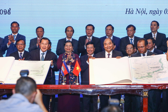 Thủ tướng Nguyễn Xuân Phúc và Thủ tướng Campuchia Hun Sen cầm trên tay bản đồ địa hình biên giới - Ảnh: NGUYỄN KHÁNH