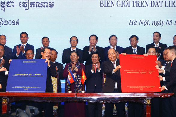 Thủ tướng Nguyễn Xuân Phúc và Thủ tướng Campuchia Hun Sen cầm trên tay văn kiện pháp lý ghi nhận thành quả công tác phân giới cắm mốc biên giới - Ảnh: NGUYỄN KHÁNH