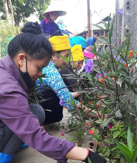 Các hội viên Chi hội phụ nữ nông thôn trồng hoa bên đường