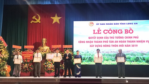 Chủ tịch UBND tỉnh Long An - Nguyễn Văn Út (đứng giữa) trao bằng khen cho các tập thể có thành tích xuất sắc trong phong trào xây dựng nông thôn mới của TP.Tân An