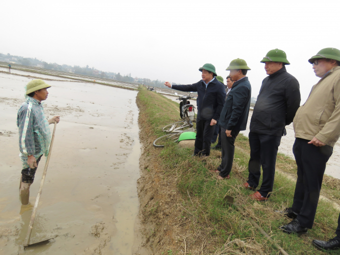 Thứ trưởng thăm hỏi, căn dặn nông dân xã Duy Ninh (huyện Quảng Ninh) lưu ý chống rét cho mạ non trong thời tiết giá lạnh. Ảnh: N.Tâm.