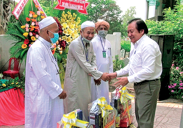 Ông Men Pholly, Trưởng Ban Dân tộc tỉnh An Giang (bìa phải), tặng quà và chúc mừng tháng Ramadan.