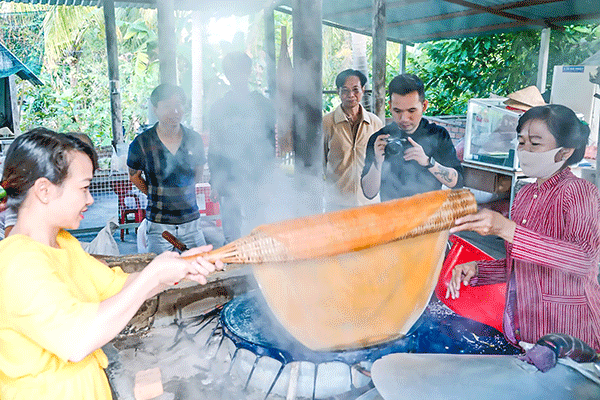 Du khách trải nghiệm làm hủ tiếu ở lò hủ tiếu Sáu Hoài, quận Ninh Kiều.